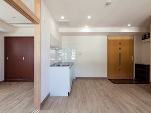真ん中にミニキッチン、奥のほうに収納がある広めの居住スペースの写真