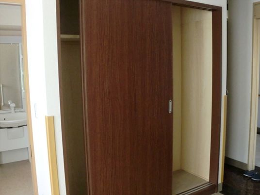 施設内居室に備え付けてある収納部分の写真。奥のほうに洗面台があるのがわかる