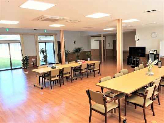 木製のテーブルセットが複数並べられている。窓が多く、明るい雰囲気。