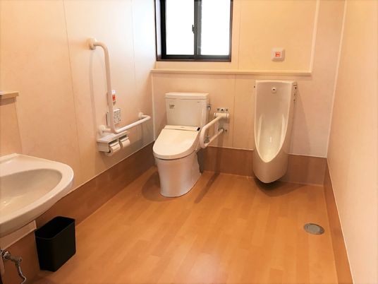 エル字型の手すりや呼び出しボタンがあるトイレは、広さも十分確保されている。男性用トイレもある。