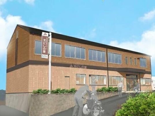 ブラウン系の２階建ての建物。敷地内には駐車スペースもあり、玄関には屋根が付いている。