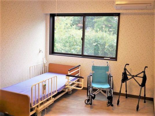 車いすや歩行器、ベッドなどが窓際に並んでいる。