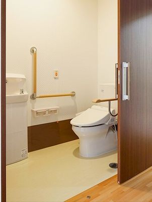 手すりがついた引き戸仕様のトイレの様子。居室内にある設備の写真