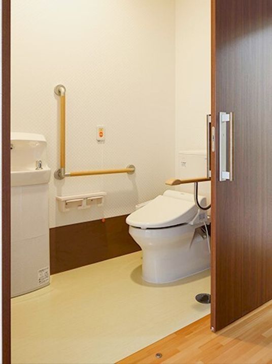 手すりがついた引き戸仕様のトイレの様子。居室内にある設備の写真