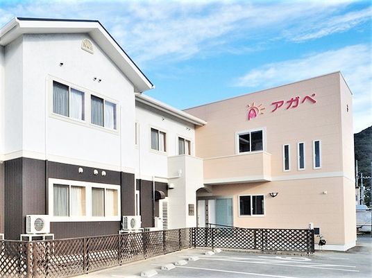 白と黒の建物とベージュの建物は2階建て。