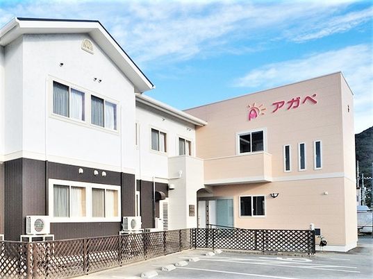 白と黒の建物とベージュの建物は2階建て。