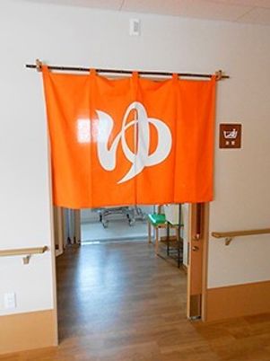 「ゆ」の暖簾が掲げられた浴室の前の様子。施設内の浴室の写真