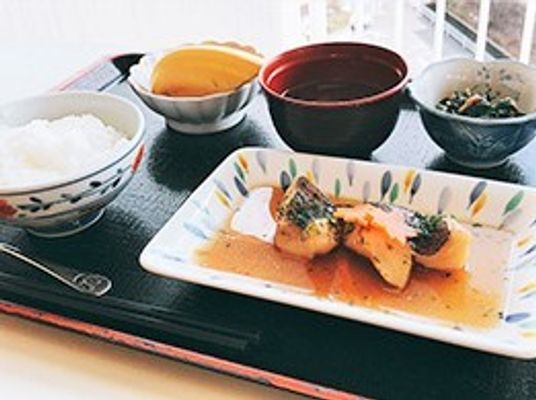 ごはんとおかず数種類、みそ汁などがのっているある日のメニュー例