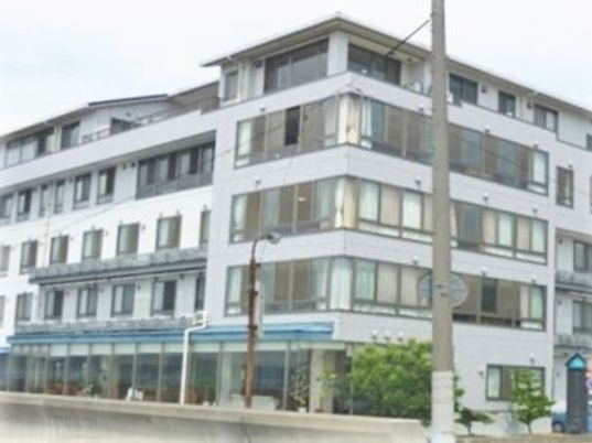 普通のマンションのような外観の介護付き住宅。屋上がある大きな建物
