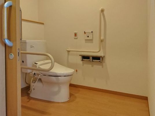 手すり付きのトイレの様子。緊急コールがすぐそばに付いている様子が写っている介護仕様のトイレ