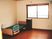 介護用ベッドや物置が置いてある小さなワンルームタイプの部屋。奥のほうに窓があり外につながっている