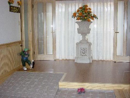 施設のエントランス部分の写真。花が飾ってあるスペース。オールバリアフリーの構造がわかる