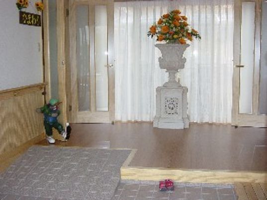 施設のエントランス部分の写真。花が飾ってあるスペース。オールバリアフリーの構造がわかる