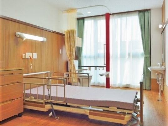フローリングの居室にはカーテン付きのトイレや家具、エアコンが付き、日当たりもいい。