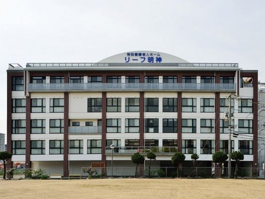 大きな5階建ての建物は白を基調としていて、ブラウンのラインが入っている。