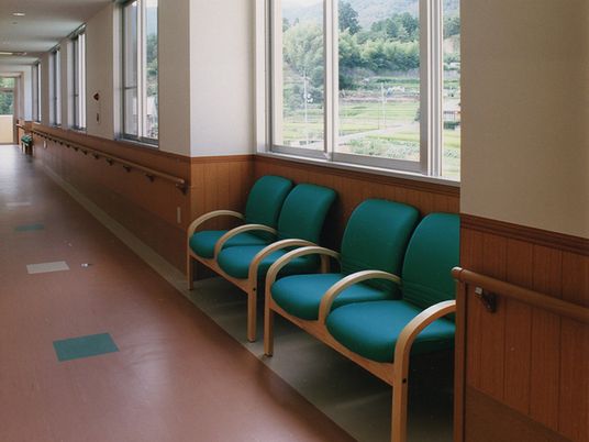 長い廊下にベンチが用意してある様子。まんべんなく取り付けられた手すり