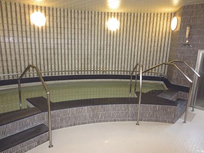 大きな浴槽には手すりが付いた階段が付き、お湯がたっぷりと張られている。