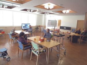 入居者が複数名くつろいでいる食堂には少人数向けのテーブルセットが置かれ、テレビも置かれている。