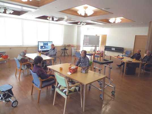 入居者が複数名くつろいでいる食堂には少人数向けのテーブルセットが置かれ、テレビも置かれている。