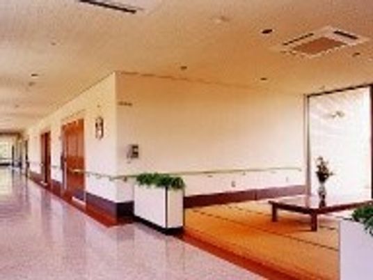 畳スペースにはテーブルが置かれ、廊下には全域手すりが設置され、居室は引き戸となっている。