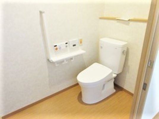L字型の手すりがついた施設内のトイレの様子。居室内にも取り付けられている