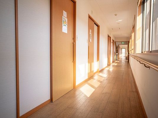 右側に窓、左側には居室のドアが並んだまっすぐな廊下。日当たりがよく、居室のドアはすべてスライド式。