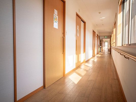 右側に窓、左側には居室のドアが並んだまっすぐな廊下。日当たりがよく、居室のドアはすべてスライド式。