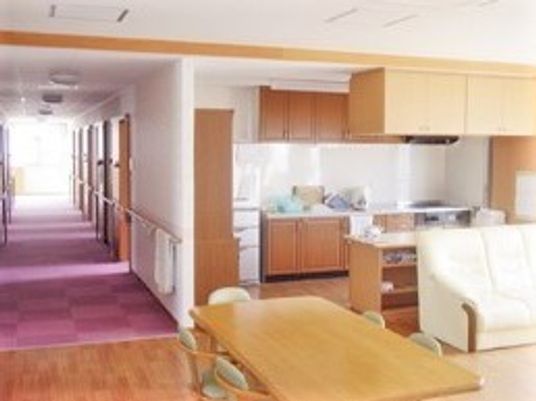 木をふんだんに使った空間と手枚にある調度品の様子。左側に廊下が続いているリビング