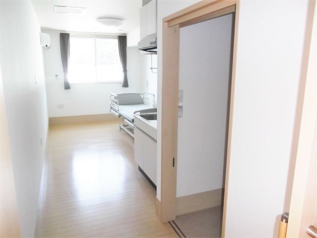 出入り口から居室を見渡した様子。ベッドやキッチン、トイレのドアが見える。 介護度に応じたきめ細かなサポートができるよう、様々な種類の事業所がございます。