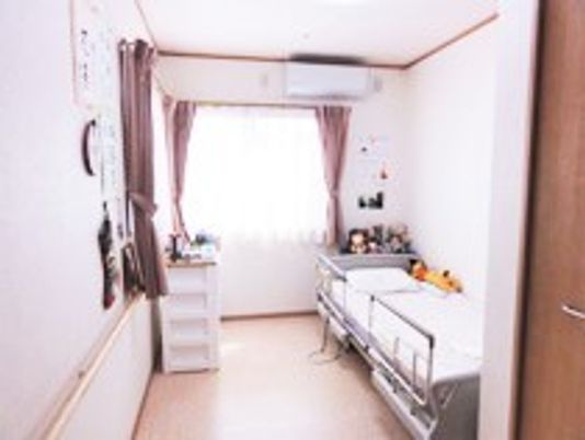 小さな部屋の中にベッド、タンス、その他調度品類が置いてある様子。施設内の居室の写真