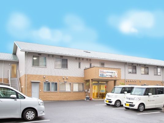 2階建ての建物には広い駐車場が付き、玄関先には屋根もついている。