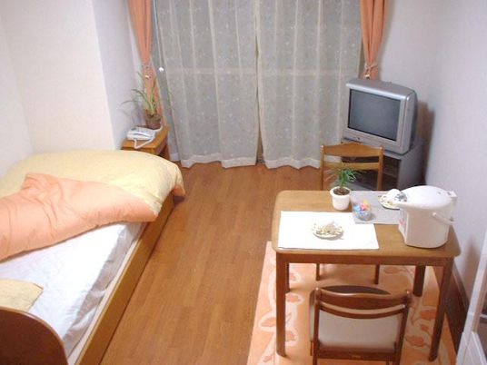 テレビやベッド、小さなテーブルと椅子が置いてある施設内のひとり部屋