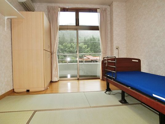 介護ベッドが置かれ、畳が敷かれている部屋には大きなクローゼットが置かれている。