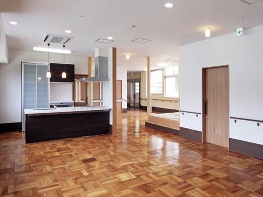 対面式キッチンが付いたリビングダイニングの壁には手すりが付き、家具や家電は置かれていない。