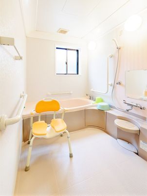 一人用の浴槽が置かれた広い浴室には、シャワーや手すり、シャワーチェアなども置かれている。
