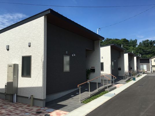 戸建てが並んでいる小さな集合住宅の写真。スロープ付きの建物
