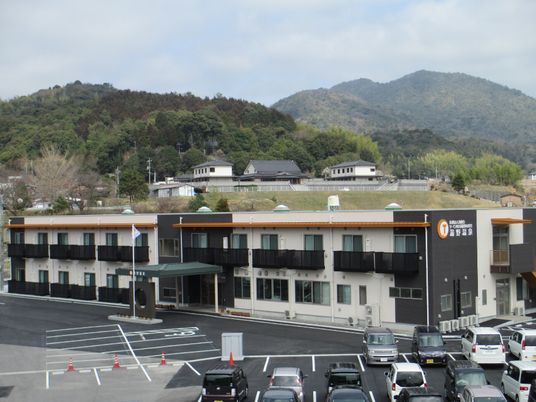 山に囲まれたサービス付き住宅湯野温泉の外観を遠めから写したもの