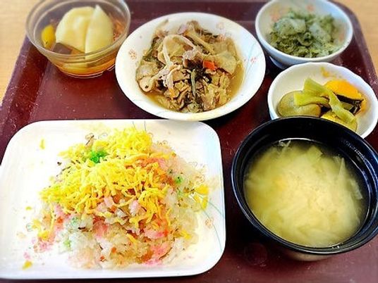 散らす寿司には錦糸卵が乗っていて、みそ汁や野菜の煮物、和え物やフルーツなどが盛られ、木製のトレーに並んでいる。