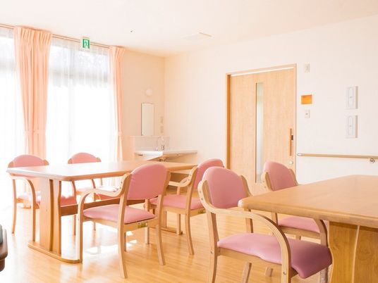 木製の4人掛けのテーブルが並ぶ食堂。大きな窓が付き、屋外の景色を眺めることができる。