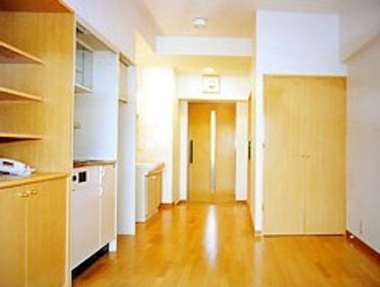 オールバリアフリーでフローリングの床の居室。ミニキッチンと収納棚があるのがわかる