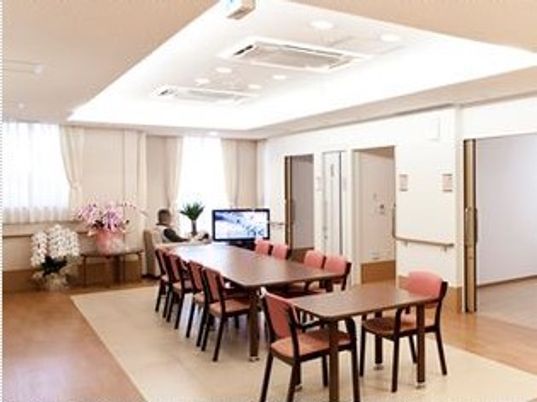 柔らかい光が注いでいるリビングの様子。木製の椅子、机、フラットな床の様子