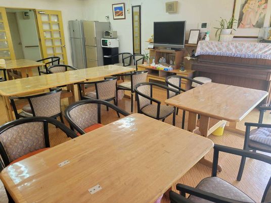 テーブルやいすが並べられているリビングスペースの様子。施設内の共有スペース