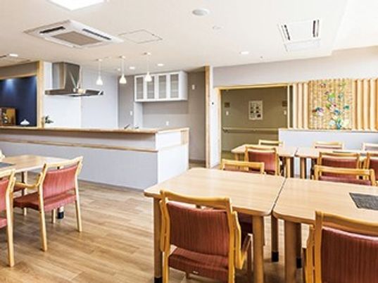 木製のダイニングテーブルが並んだ食堂には対面式キッチンが設置され、アットホームな雰囲気。