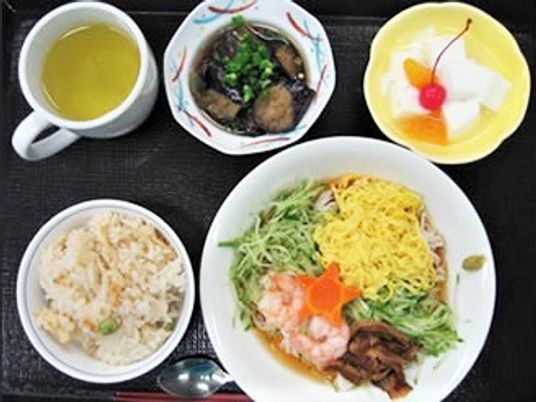 五目そうめんに炊き込みご飯、煮物にデザートが付いた食事。