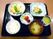 品数の多い食事。白いご飯に味噌汁、お茶、野菜たっぷりのおかずが並んでいる。