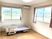 大きな窓が二つ付いたフローリングの部屋には介護ベッドやエアコンが設置され、窓の外には自然が広がっている。
