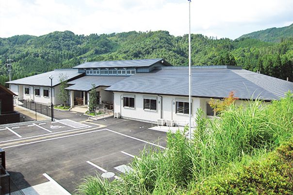 周囲を山に囲まれた場所に建つグループホームほしのさとの外観写真