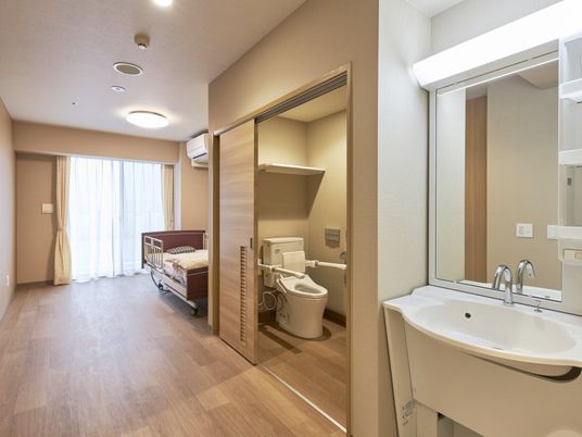 介護用ベッドとトイレ、洗面所が設置されている個室