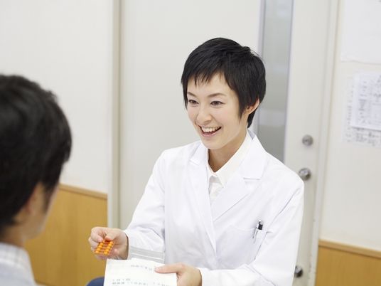 患者らしき人に説明している医療従事者。優しく説明している様子が分かる