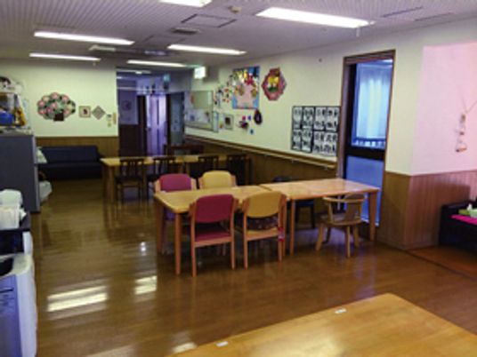 ダイニングテーブルが複数並んだ食堂には入居者の作品も飾られている。